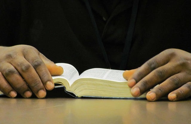 Pessoa com a Bíblia aberta, mostrando somente as mãos