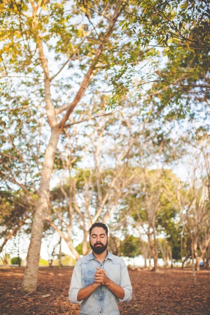 Você já orou hoje?man with eyes closed and clasped hands in front of chest under green tree