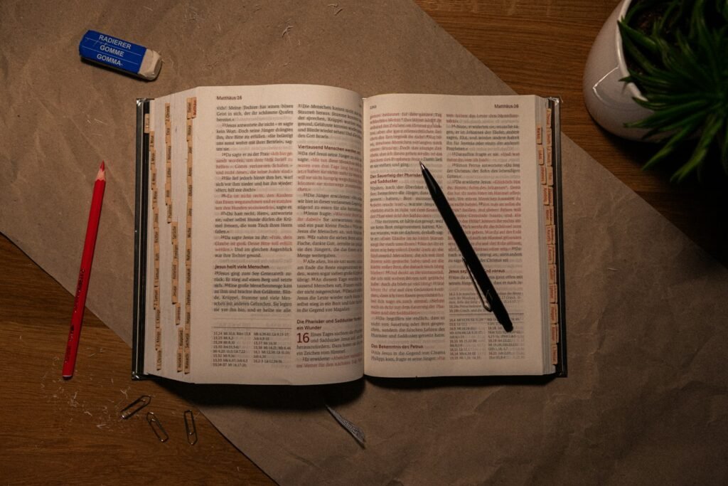 Discipulado: An open book on a table with a pen and pencil