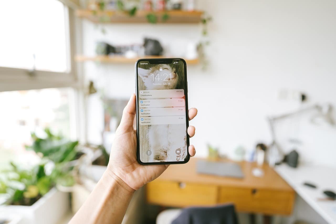 uma pessoa segurando um smartphone com um aplicativo de leitura da Bíblia aberto