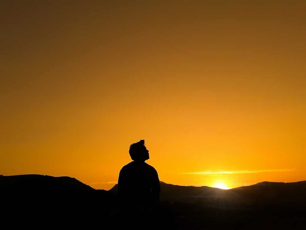 Comece o dia agradecendo: silhouette of man standing on hill during sunset