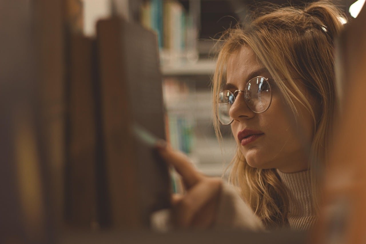 uma jovem refletindo enquanto lê um livro de Provérbios